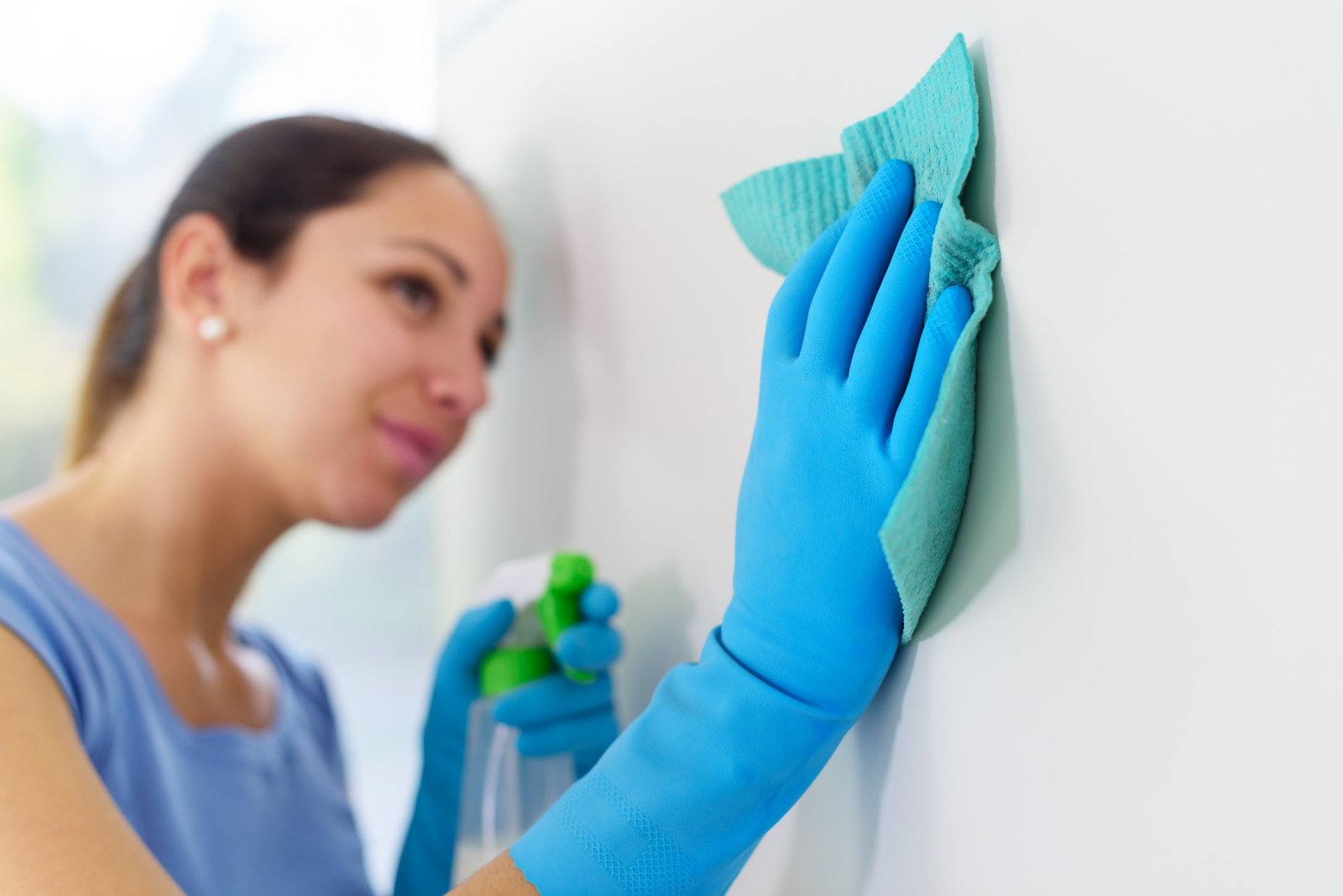 Person behandelt Schimmelflecken an einer Wand